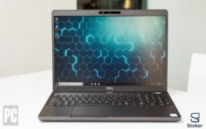 لپتاپ استوک Dell Precision 3540، رنگ خاکستری تیره، در یک نمای نزدیک روبرو و باز. صفحه نمایش روشن با تصویر پس‌زمینه شش ضلعی‌های نوری آبی و مشکی دیده می‌شود. کیبورد کامل و تاچ‌پد بزرگ نیز مشخص است.